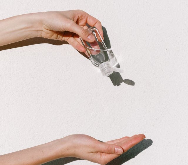 person holding hand sanitizer 3962332